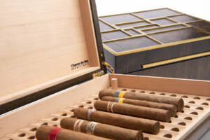 Cigares soigneusement rangés dans une cave à cigares en cèdre massif et robinier fumé, garantissant conservation optimale et élégance artisanale.