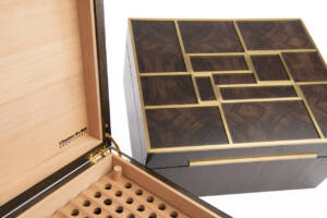 Détail des inserts en laiton massif et du placage de robinier fumé sur une cave à cigares artisanale haut de gamme signée L’Essence des Bois.