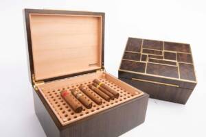 Cigares soigneusement rangés dans une cave à cigares en cèdre massif et robinier fumé, garantissant conservation optimale et élégance artisanale.